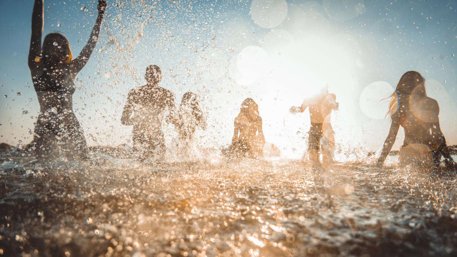 ocean splash with silhouette of 4 people in background